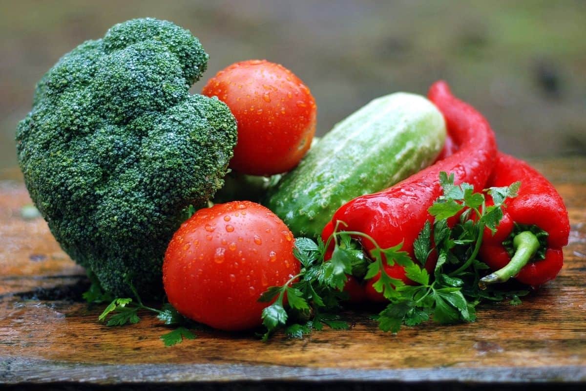 Fresh Broccoli, Zucchini, Tomatoes, and red hot peppers on a wooden surface