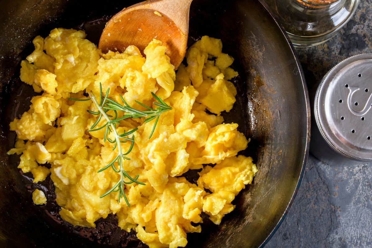 Scrambled egg in small cast-iron skillet. Making omelet eggs. Stock Photo  by ©boomeart 327353544